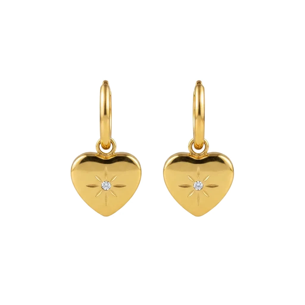 Gold heart-shaped pendant earrings with a starburst design and a small clear stone.