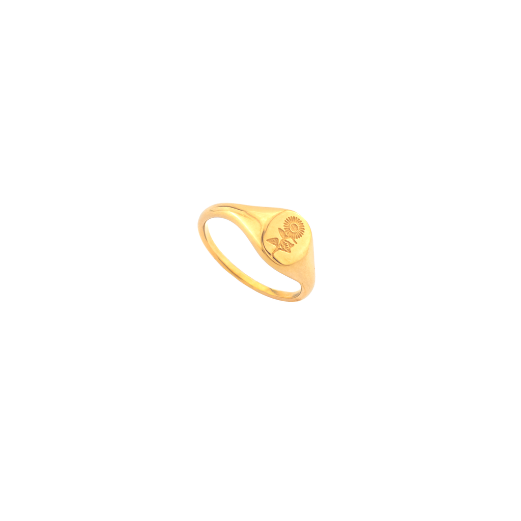 A polished yellow gold signet ring featuring an engraved rose motif on its oval face.