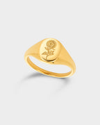 A polished yellow gold signet ring featuring an engraved rose motif on its oval face.