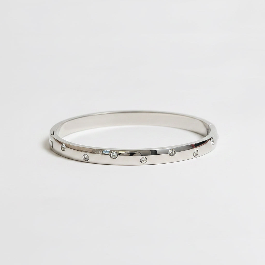 One slim silver bangle bracelets with small clear rhinestones.