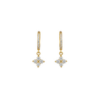A gold huggie hoop earring with a dangling floral clover charm set with clear stones.