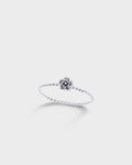 A delicate silver ring featuring a twisted band and a small central flower-like charm.
