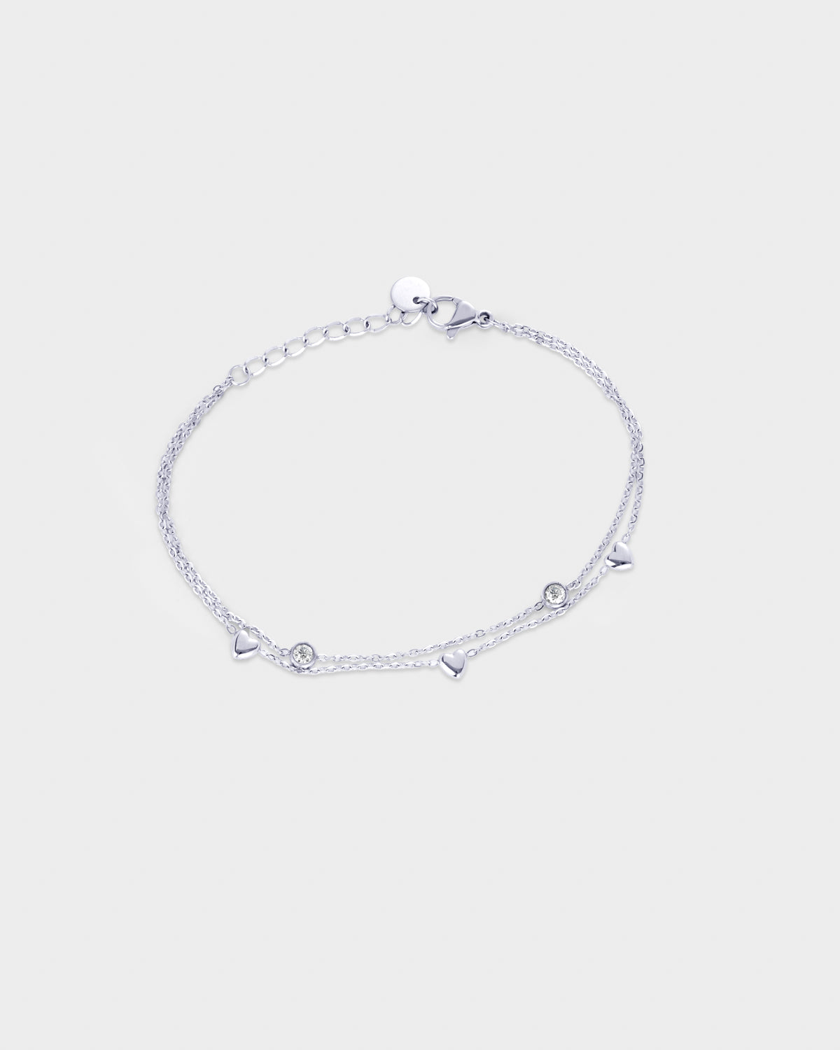 A delicate silver chain double layered bracelet featuring small dangling circle and heart charms.