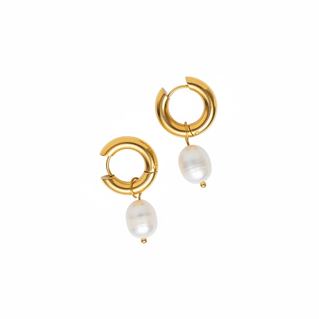 A pair of gold huggie hoop earrings with dangling white pearl beads.