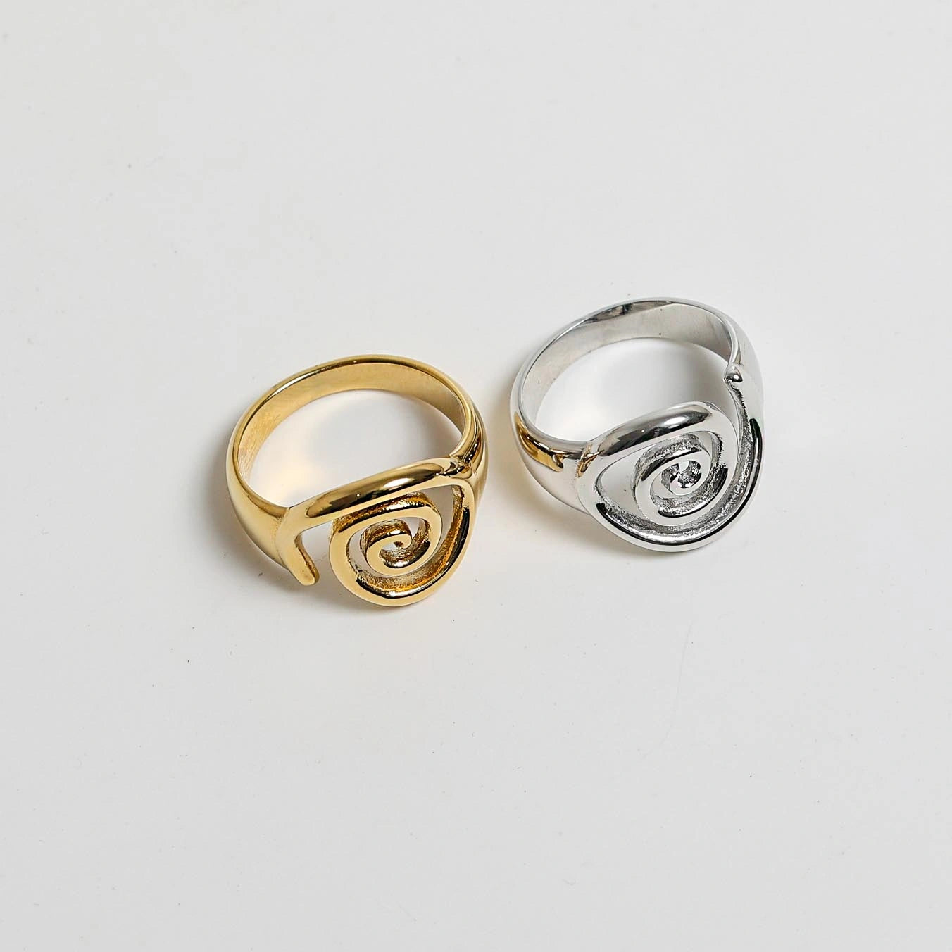A gold ring with a sculptural, open spiral design.